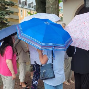 grupa kilku osób z otwartymi parasolami nad głowami