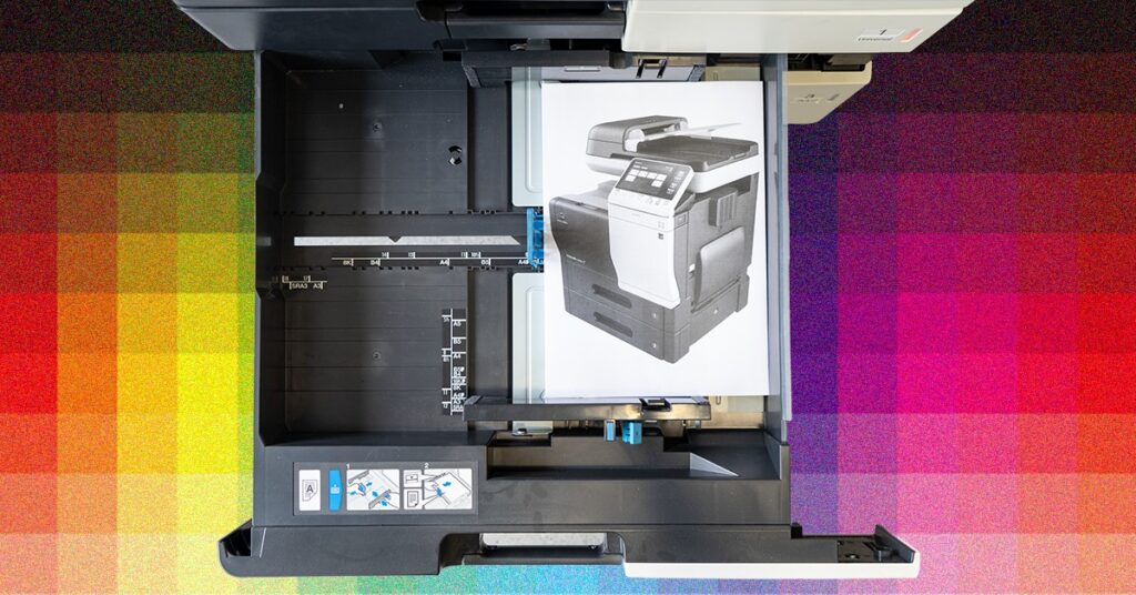 Grafika promująca spotkanie Otwartej Pracowni Fotografii WBPiCAK. Na grafice widoczne zdjęcie drukarki, wydrukowane na kartce papieru. Kartka papieru z nadrukiem drukarki została umieszczona w szufladzie drukarki. Tło składa się z różnokolorowych kwadratów przechodzących w gradient.