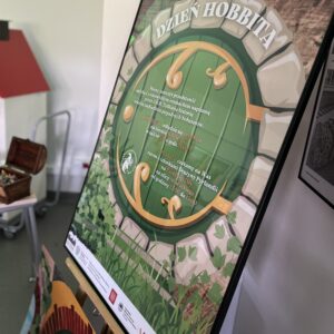 kolorowy plakat przedstawiający okrągłe wejście do domku hobbita