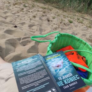 Torba z książką leżące na plaży
