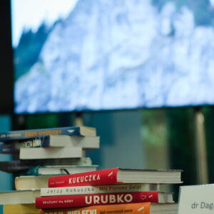widać książki o górach, w tle na monitorze zdjęcie szczytu