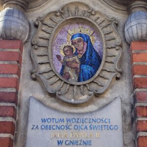 zdjęcie ozdobnego frontonu przedstawiające mozaikę z wizerunkiem Matki Boskiej z Dzieciątkiem oraz napis: Wotum wdzięczności za obecność Ojca Świętego Jana Pawła II w Gnieźnie 3-4 VI 1979 2-4 VI 1997