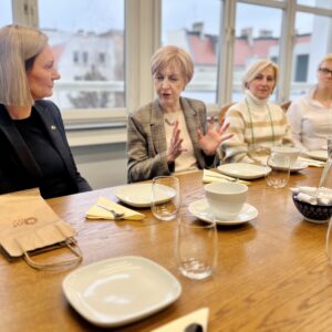 cztery kobiety pogrążone w rozmowie siedzą przy stole