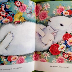 otwarta książka z dużym rysunkiem dużego i małego królika wśród kwiatów