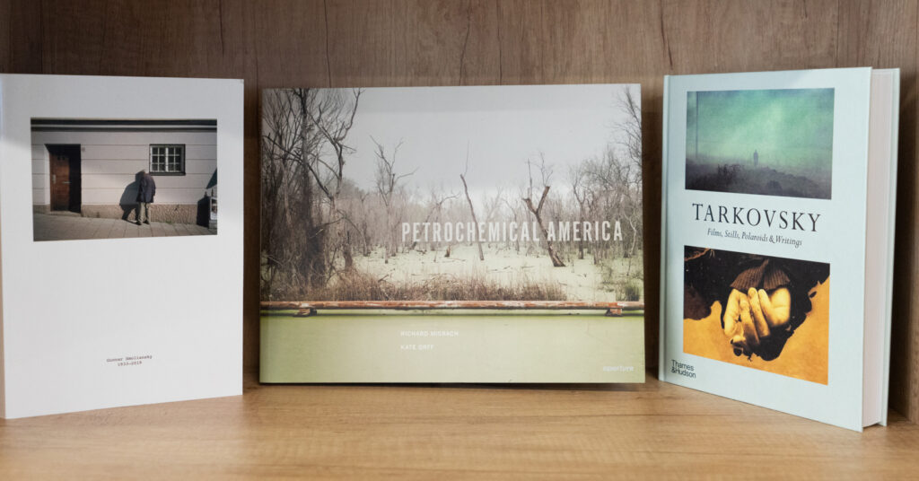 Fotografia ukazująca 3 ksążki o tematyce fotograficznej, ustawionej na półce.